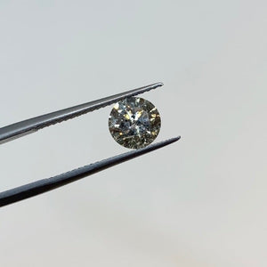 
                  
                    Load image into Gallery viewer, Front view of a 1.25 ct. round salt and pepper diamond in tweezers.
                  
                