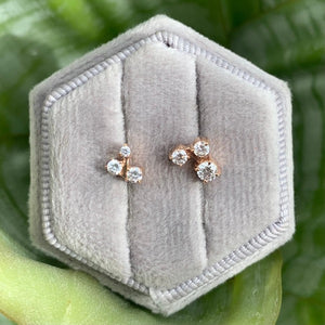 
                  
                    Load image into Gallery viewer, front view on grey display box of cluster-style diamond studs in 14 kt rose gold. Total carat weight of varied round diamonds are 0.27 ct. 
                  
                