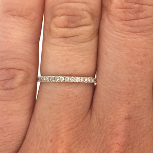 
                  
                    Load image into Gallery viewer, A 3/4 diamond eternity band set with round cut diamonds in a 14 kt white gold setting on wearer&amp;#39;s left ring finger for scale.
                  
                