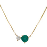 Front view of an asymmetrical round cut emerald and diamond necklace cast in 14 kt yellow gold.