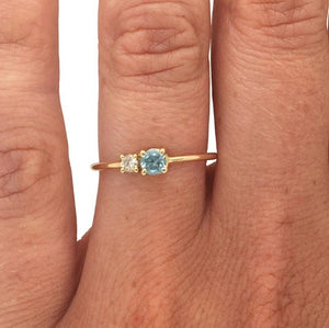 
                  
                    Load image into Gallery viewer, Round cut blue zircon and diamond ring cast in 14 kt yellow gold on left ring finger.
                  
                