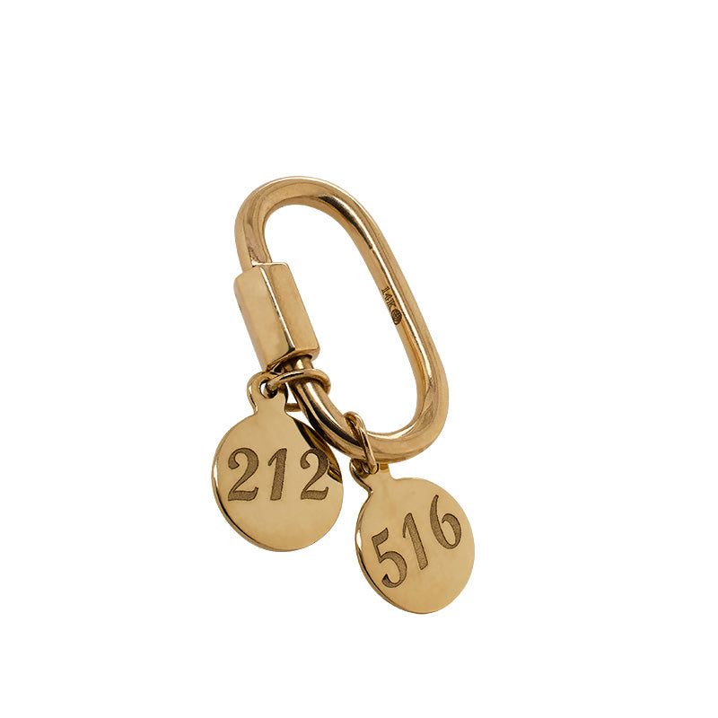 Image of 14kt yellow gold carabiner lock with gold, "212" and "516" area code pendants hanging from it. 