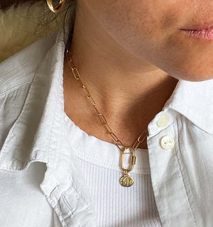 
                  
                    Load image into Gallery viewer, 14 kt yellow gold carabiner and two 14 kt yellow gold area code pendants on 14 kt gold paperclip chain around a woman&amp;#39;s neck for perspective.
                  
                