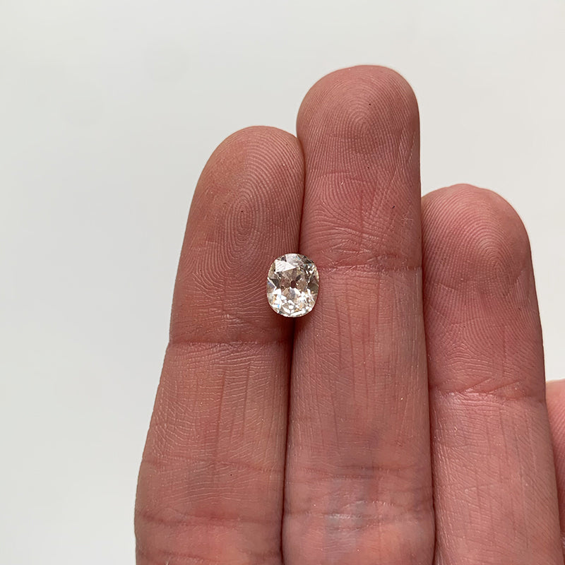 View of 0.91 ct old mine cut cushion white diamond on ladies hand for scale.