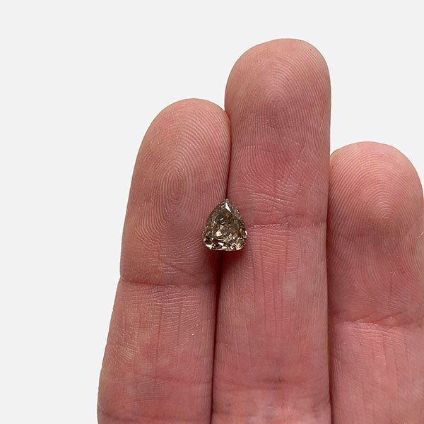 
                  
                    Load image into Gallery viewer, Front view of a 1.06 ct light brown pear diamond on a ladies hand for scale.
                  
                