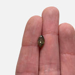 Front view of a 1.19 ct earthy green salt and pepper marquise cut diamond on ladies hand for scale.