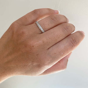 
                  
                    Load image into Gallery viewer, View of 0.90 tcw pavé set eternity band on left ring finger, and cast in 14 kt white gold.
                  
                