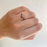 Front view on left ring finger of a round cut, black diamond shadow band with a tcw of 0.47, and cast in 14kt rose gold.