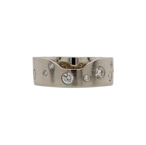 Front view of a notched out cigar band scattered with approx 0.62 ct of burnish set round cut diamonds cast in 14 kt white gold.