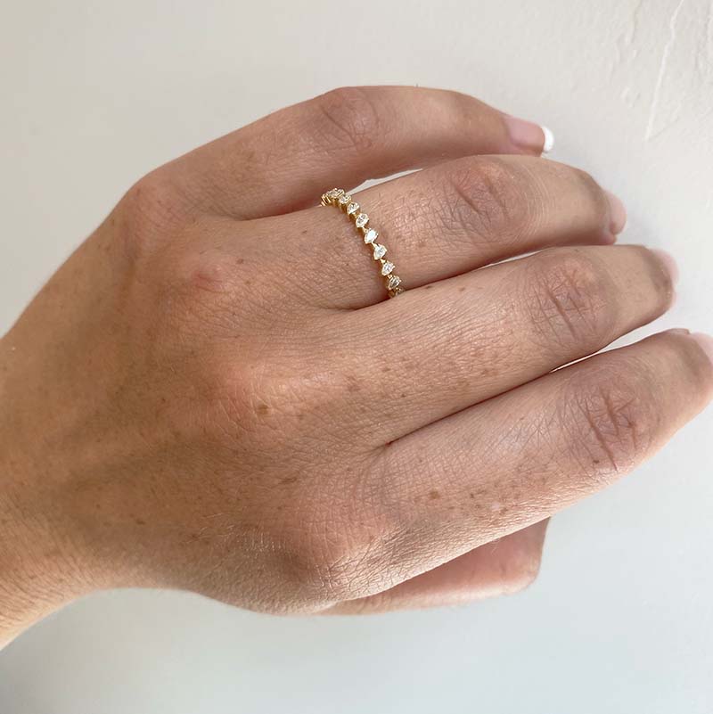 
                  
                    Load image into Gallery viewer, Front view on left ring finger of an eternity band with a 0.67 tcw of pear cut diamonds cast in 14 kt yellow gold.
                  
                