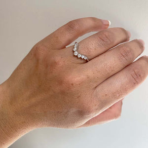 
                  
                    Load image into Gallery viewer, Front view on left ring finger of shadow band with 7 round cut diamonds increasing in size from the outside in, set in 14 kt white gold.
                  
                