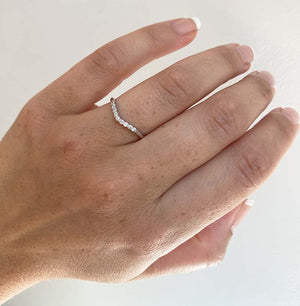 
                  
                    Load image into Gallery viewer, Front view on left ring finger of a shadow band with a subtle center dip, adorned with 9 round cut diamonds and set in 14 kt white gold.
                  
                