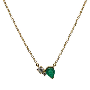 
                  
                    Load image into Gallery viewer, Front view of an asymmetrical round cut double diamond and pear cut emerald necklace in a 14 kt yellow gold setting with a gold chain.
                  
                