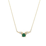 Front view of a round cut double diamond and round cut emerald pendant necklace cast in 14 kt yellow gold.