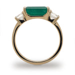 Side view of Columbian emerald ring flanked with 2 asscher cut diamonds set in 14 kt yellow gold.