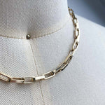 Close up of smaller sized, flat-link, squared edge paperclip necklace, cast in 14kt yellow gold.