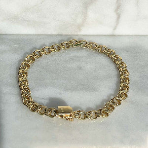 
                  
                    Load image into Gallery viewer, Overhead view of a solid 14kt yellow gold 7&amp;quot; vintage style multi ring/link bracelet with a box clasp style closure. 
                  
                