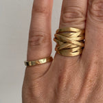 Closeup shot of 18tk yellow gold Andrea ring on ring finger. Hand is also styled with a 3mm gold band on the pinky finger.