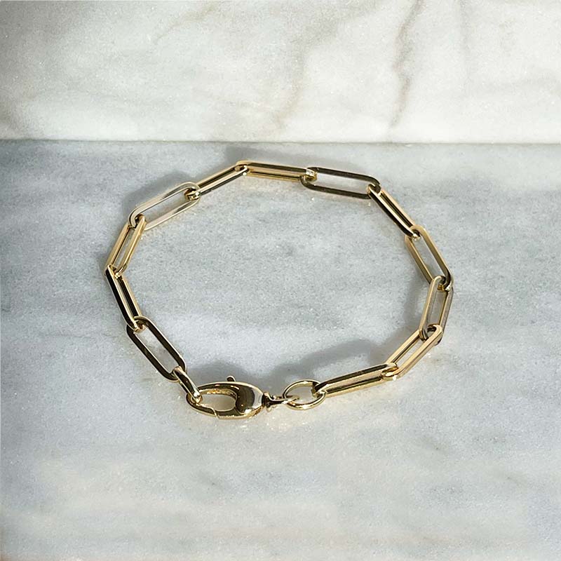 Overhead view of a solid 14kt yellow gold 7" medium gauge paperclip style bracelet with a lobster clasp style closure.