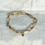 Overhead view of a solid 14kt yellow gold box chain style 7" bracelet with a lobster clasp style closure. 