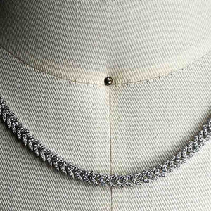 
                  
                    Load image into Gallery viewer, Close up of a pavé set crystal necklace in a sterling silver herringbone style setting on a body form for scale.
                  
                
