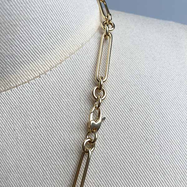 
                  
                    Load image into Gallery viewer, Close up image of oval clasp on larger paperclip chain with 3 round link in 14kt yellow gold.
                  
                