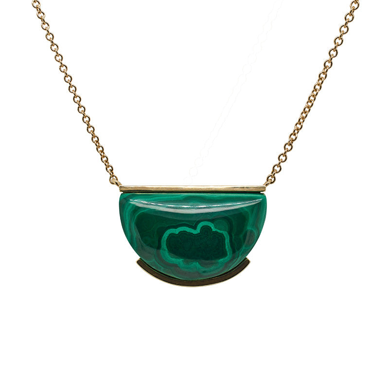 Front view of a malachite necklace suspended on 14 kt yellow gold chain. The malachite stone is cut in a half moon shape and is partially bezel set on both the top and bottom of the stone.