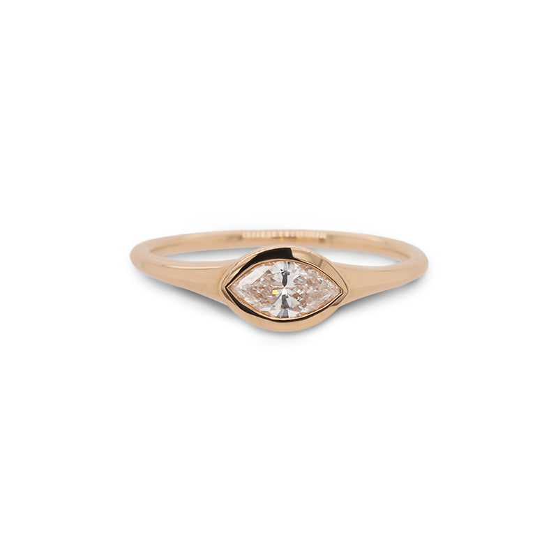 Front view of bezel set, marquise cut diamond ring set in 14 kt yellow gold.