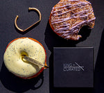 Two brass cuffs and donuts from the  King + Curated and NoFoDoCo collaboration .