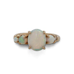 Front view of an asymmetrical opal and diamond ring cast in 14 kt yellow gold.