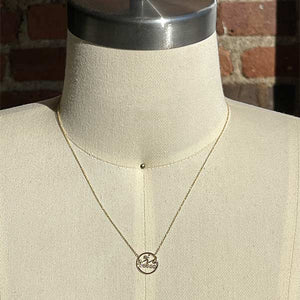 
                  
                    Load image into Gallery viewer, A circular pendant necklace with 3 asymmetrical bars and 8 round cut diamonds cast in solid 14 kt yellow gold on a body form.
                  
                