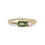 Front view of an asymmetrical oval cut, green sapphire and diamond ring cast in 14 kt yellow gold by King + Curated.