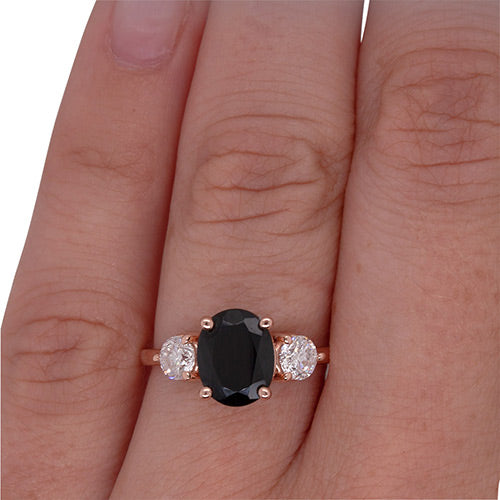 
                  
                    Load image into Gallery viewer, Oval cut black sapphire and round cut diamond ring set in 14 kt rose gold on left ring finger.
                  
                
