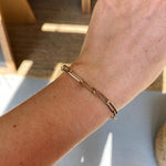 View of 14kt yellow gold paperclip bracelet on wrist.