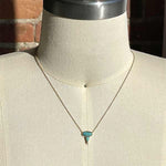 Oval and pear cut turquoise and round diamond necklace cast in 14 kt yellow gold on a body form.