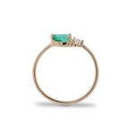 Side view of pear cut emerald and round diamond ring cast in 14 kt yellow gold.
