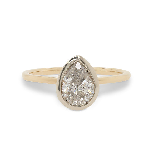 Front view of a bezel set, pear cut, salt and pepper diamond solitaire ring cast in 14 kt yellow gold by King + Curated.
