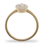 Side view of a bezel set, pear cut, salt and pepper diamond solitaire ring cast in 14 kt yellow gold by King + Curated.