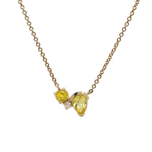 
                  
                    Load image into Gallery viewer, Front view of an asymmetrical round and pear cut yellow sapphire and round cut diamond necklace cast in 14 kt yellow gol
                  
                