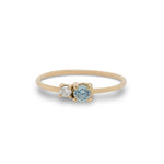 Front view of round cut blue zircon and diamond ring cast in 14 kt yellow gold.