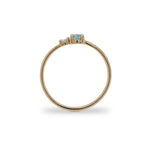 Side view of round cut blue zircon and diamond ring cast in 14 kt yellow gold.
