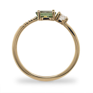 
                  
                    Load image into Gallery viewer, Side view of an asymmetrical oval cut, green sapphire and diamond ring cast in 14 kt yellow gold by King + Curated.
                  
                