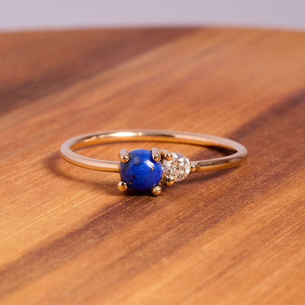 
                  
                    Load image into Gallery viewer, Front view on wood of blue lapis and diamond ring cast in 14 kt yellow gold.
                  
                