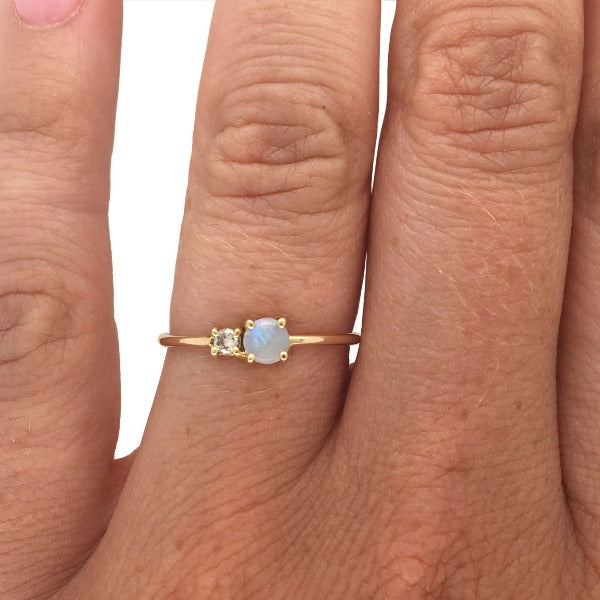 
                  
                    Load image into Gallery viewer, Petite moonstone and round diamond ring set in 14 kt yellow gold on left hand ring finger.
                  
                