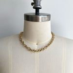 Front view on dress form of medium round link chain necklace in 14kt yellow gold. 16" length shown.