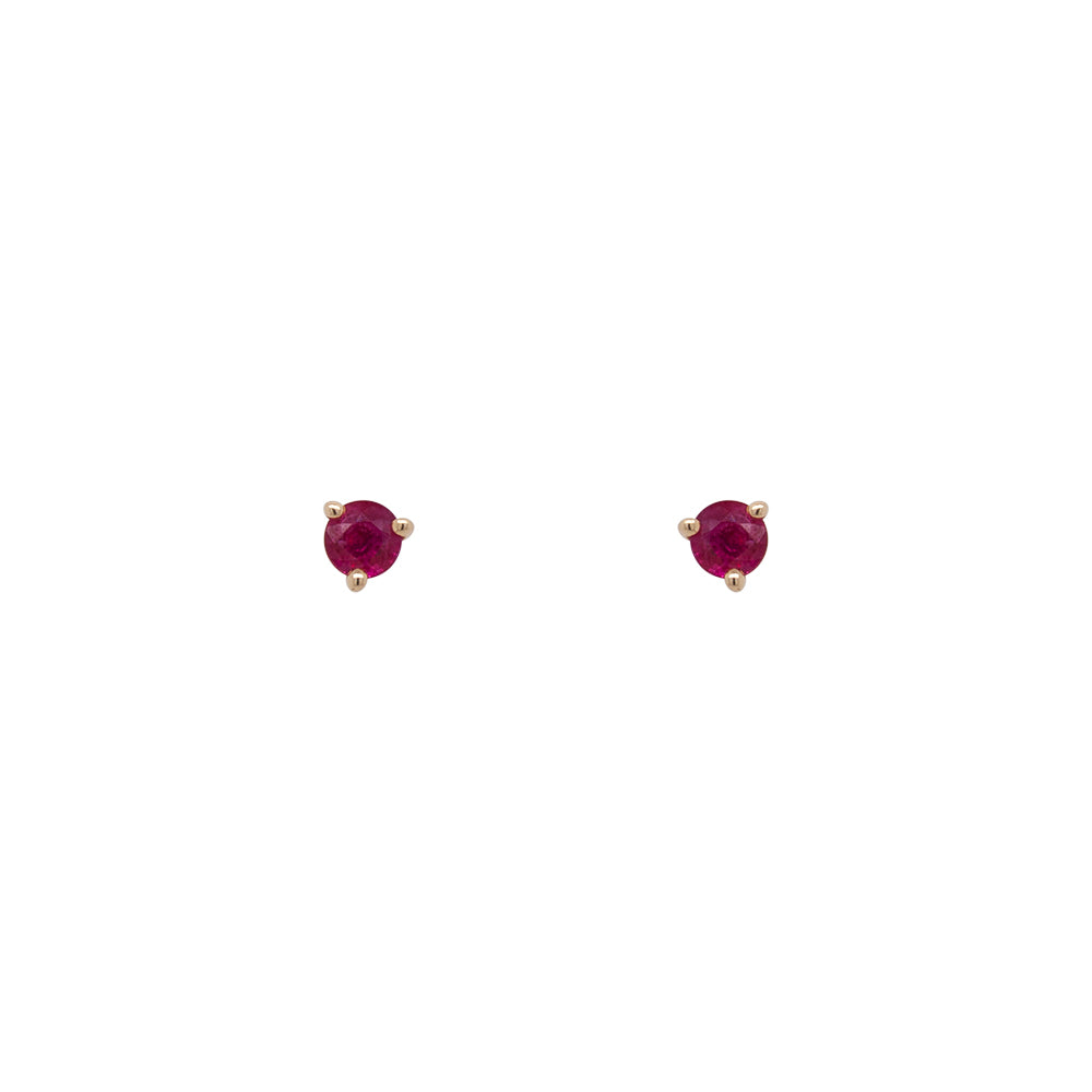 Round  cut Ruby Studs set in 14 kt yellow gold with three prongs. Displayed on a white background.