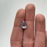 View of a 2.08 ct. geometric pear-shaped shield cut grey sapphire in ladies hand for scale.
