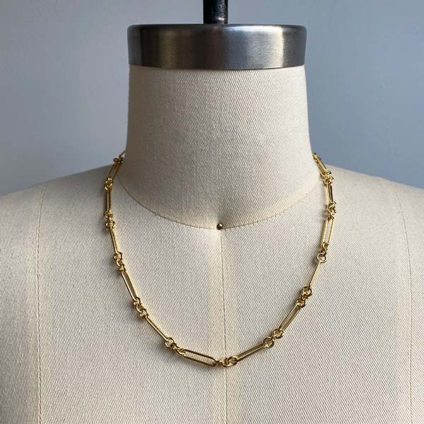 Front view of smaller paperclip chain with 3 round link pattern on dress form. 14kt yellow gold and approx 18