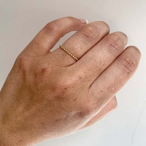 
                  
                    Load image into Gallery viewer, Front view on left ring finger of 14 kt yellow gold ring with repeat bead pattern.
                  
                