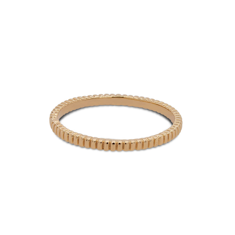 Front view of ring with a lined pattern cast in 14 kt yellow gold.